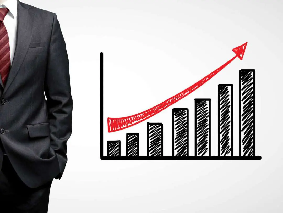 person wearing suit standing next to a bar chart indicating growth over time